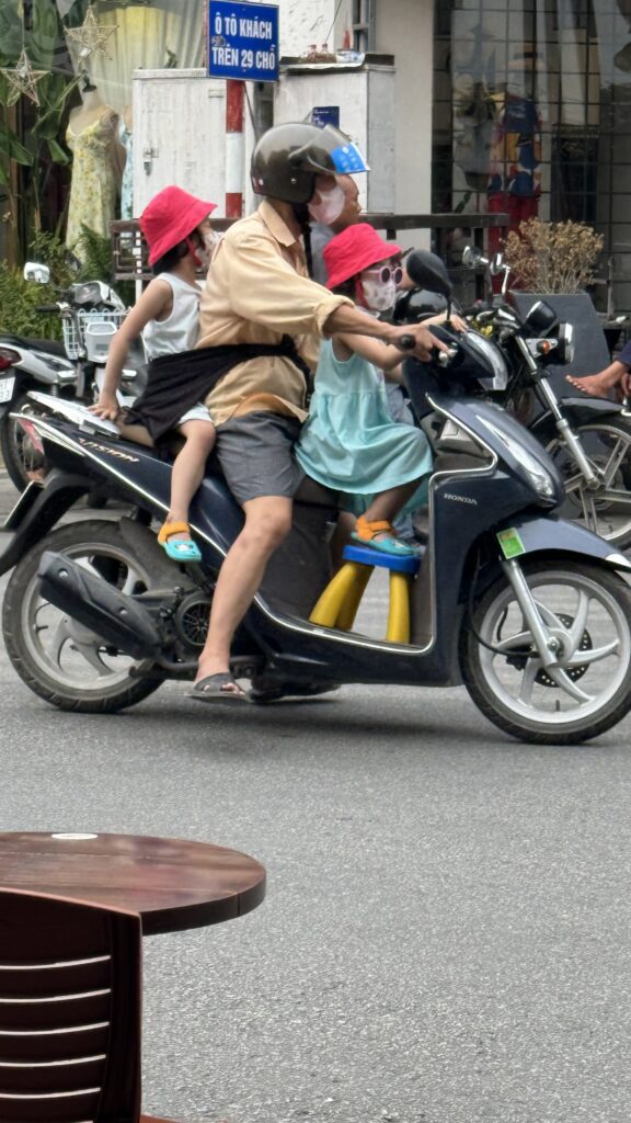 Papa mit Kindern am Moped